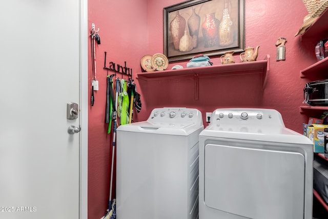 laundry area with laundry area, a textured wall, and washer and dryer