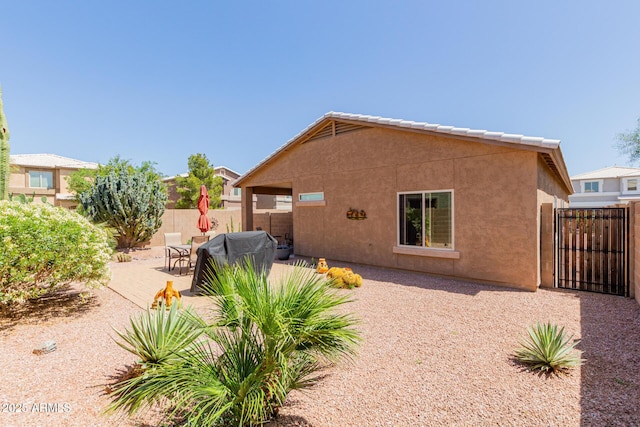 back of property featuring fence, a patio area, and stucco siding