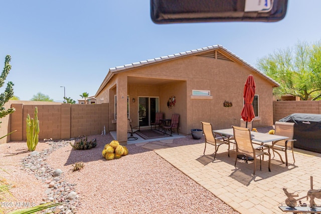 rear view of house with a fenced backyard, a patio area, and stucco siding