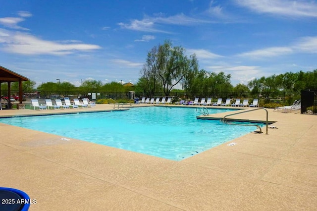 community pool with fence and a patio area
