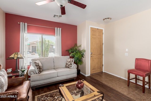 living room with a ceiling fan, baseboards, visible vents, and wood finished floors