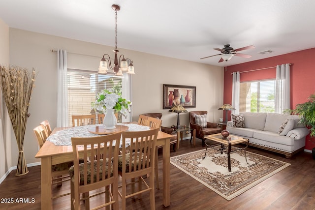 dining area featuring visible vents, wood finished floors, and ceiling fan with notable chandelier