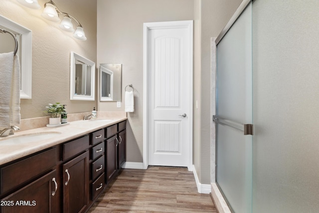 5524 N Brinson Ln, Prescott Valley, AZ 86314 - bathroom featuring a stall shower, wood finished floors, double vanity, and baseboards