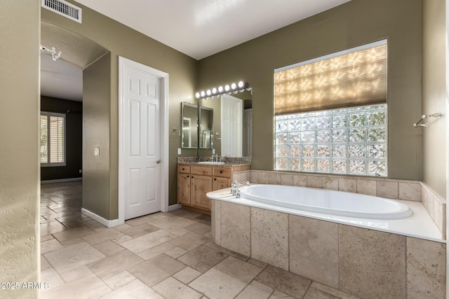 3531 E Norwood Cir, Mesa, AZ 85213 - bathroom with vanity, a bath, and stone tile floors
