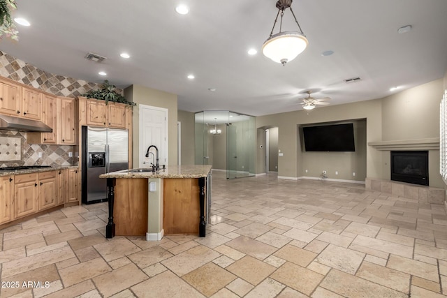 3531 E Norwood Cir, Mesa, AZ 85213 - kitchen with appliances with stainless steel finishes, under cabinet range hood, decorative backsplash, ceiling fan, and a tiled fireplace