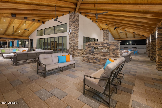 view of patio with a ceiling fan and an outdoor living space with a fireplace