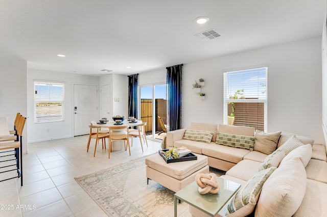 living area featuring recessed lighting, light tile patterned flooring, a healthy amount of sunlight, and visible vents