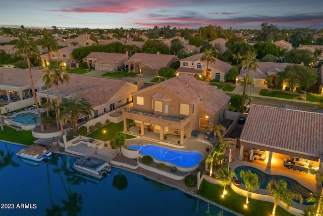 aerial view at dusk featuring a water view