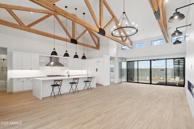 interior space with light hardwood / wood-style flooring, high vaulted ceiling, a chandelier, and beam ceiling