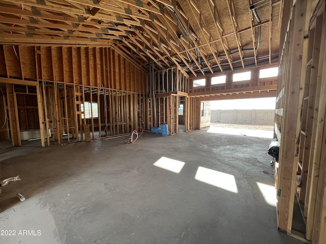 miscellaneous room with high vaulted ceiling and concrete floors