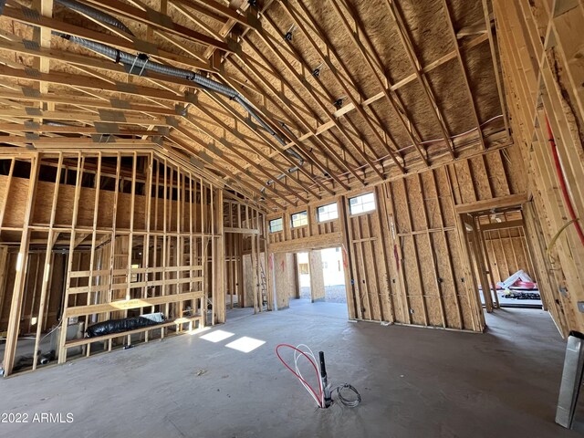 misc room featuring high vaulted ceiling and concrete floors