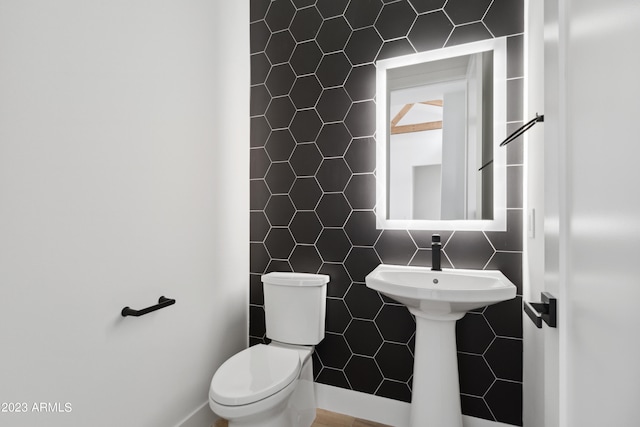 bathroom featuring backsplash, tile walls, and toilet