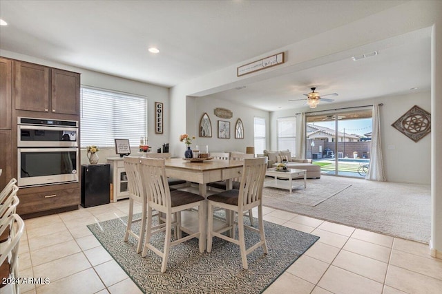 carpeted dining room with ceiling fan