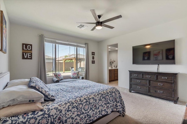 bedroom featuring ensuite bathroom, light carpet, and ceiling fan