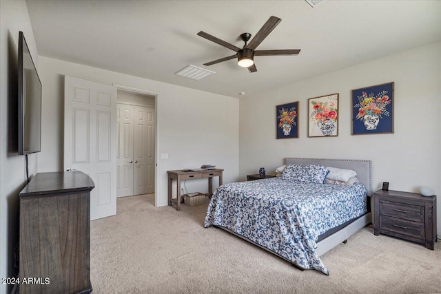 bedroom featuring ceiling fan, light colored carpet, and a closet