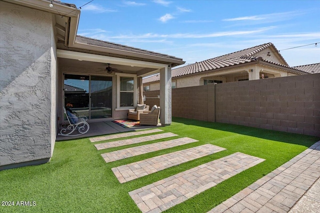 view of yard featuring a patio area and ceiling fan