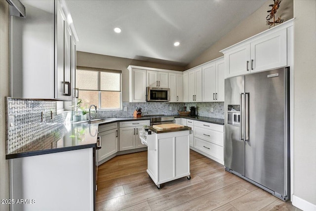 kitchen featuring white cabinetry, appliances with stainless steel finishes, a center island, and backsplash