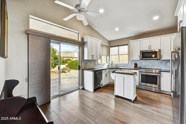 kitchen featuring white cabinetry, light hardwood / wood-style flooring, stainless steel appliances, and a center island