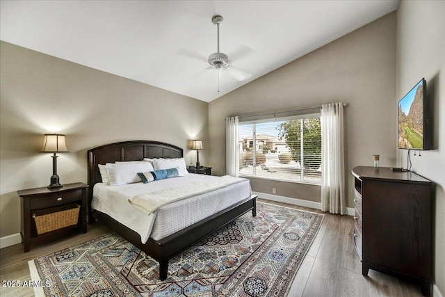 bedroom with hardwood / wood-style flooring, ceiling fan, and high vaulted ceiling