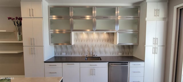 kitchen featuring sink, white cabinetry, and backsplash