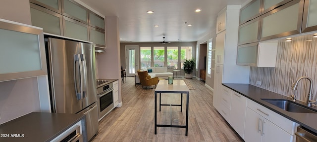 kitchen featuring light hardwood / wood-style floors, white cabinets, stainless steel appliances, and sink