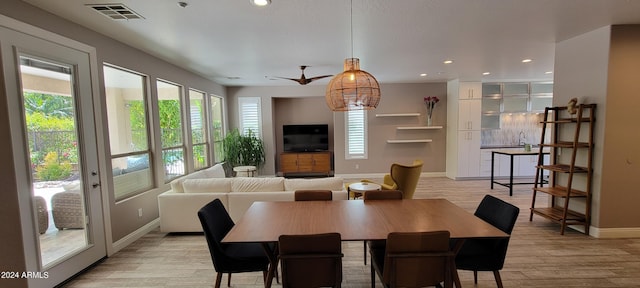 dining room with light hardwood / wood-style flooring, sink, and ceiling fan