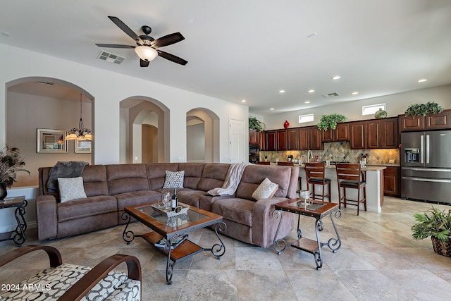 living room featuring ceiling fan with notable chandelier