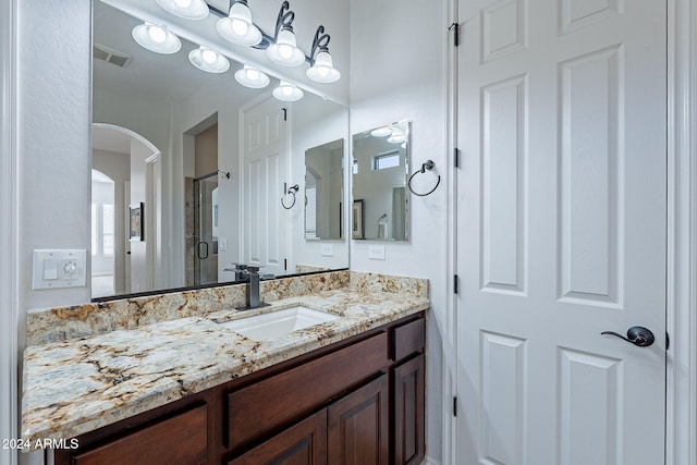 bathroom with walk in shower and vanity