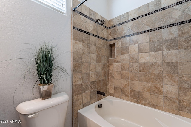 bathroom featuring toilet and tiled shower / bath combo