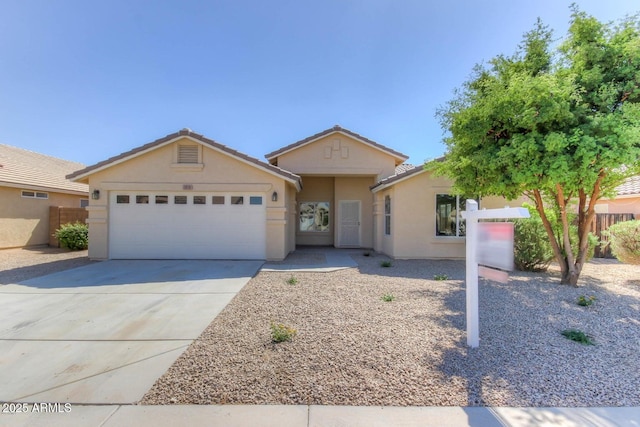 ranch-style home featuring concrete driveway, an attached garage, fence, and stucco siding