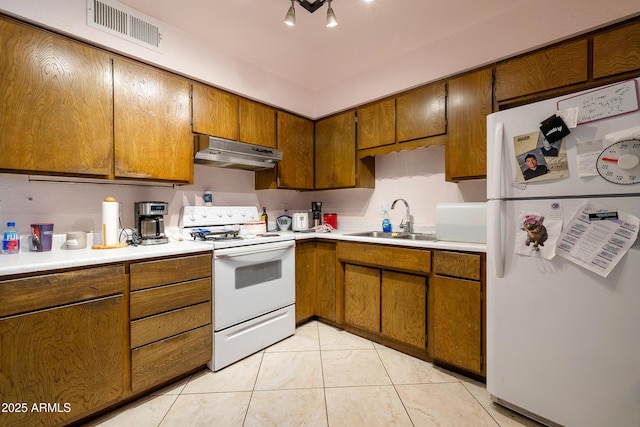 414 E Frost Cir, Mesa, AZ 85203 - kitchen with white appliances, under cabinet range hood, brown cabinetry, light countertops, and light tile patterned floors