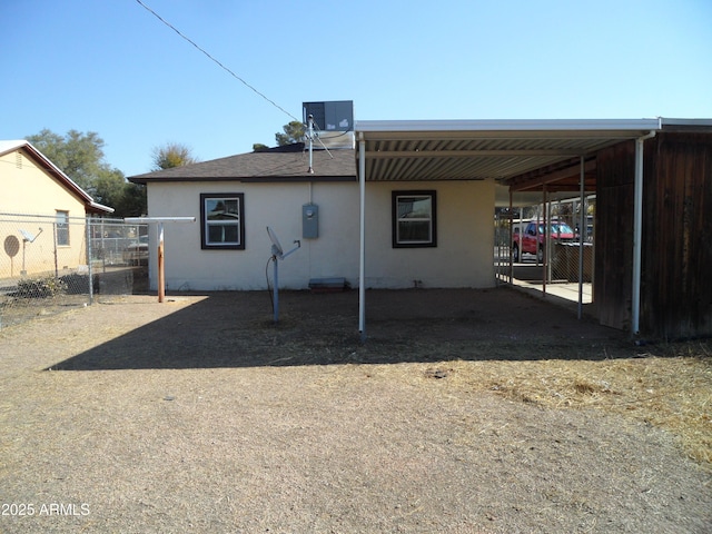 back of house featuring a carport and central air condition unit