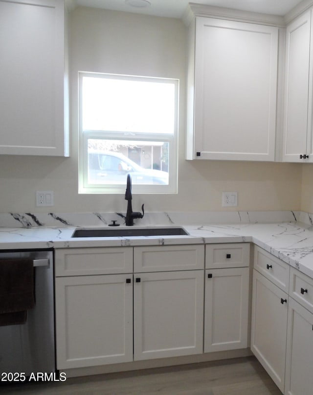 kitchen featuring sink, light hardwood / wood-style flooring, dishwasher, light stone countertops, and white cabinets