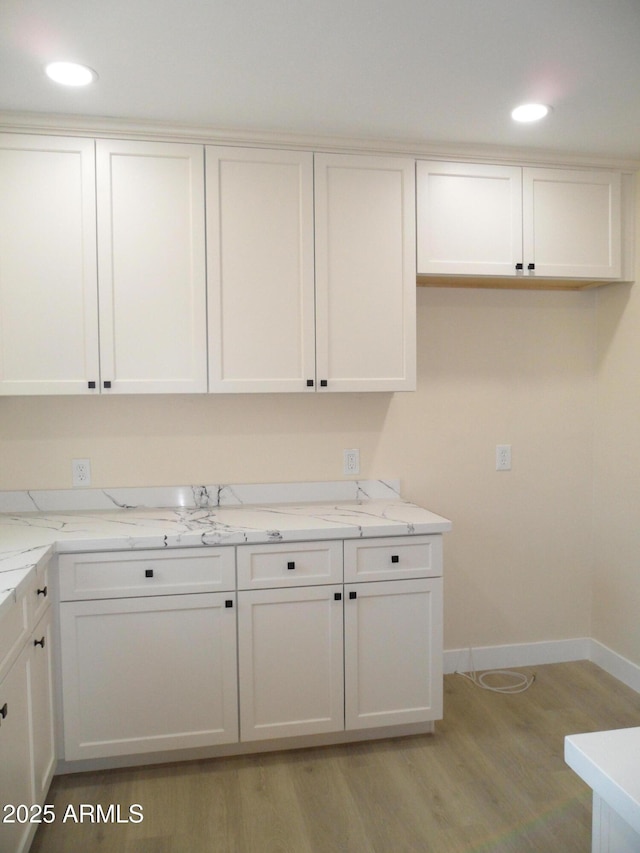 clothes washing area with light hardwood / wood-style flooring