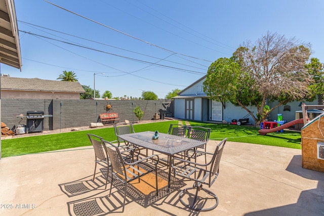 118 E 10th St, Casa Grande, AZ 85122 - view of patio featuring outdoor dining space, an outbuilding, and a grill