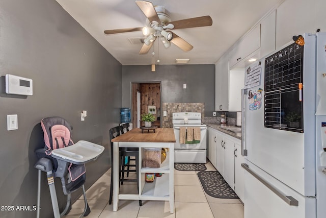 118 E 10th St, Casa Grande, AZ 85122 - kitchen with white electric range, a ceiling fan, light tile patterned flooring, white cabinets, and tasteful backsplash