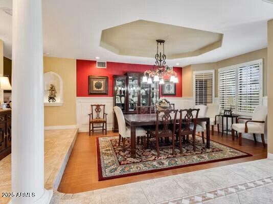 10434 N 44th St N, Phoenix, AZ 85028 - dining area featuring ornate columns, a raised ceiling, wainscoting, tile patterned flooring, and a chandelier