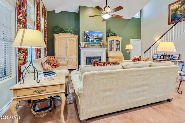 10434 N 44th St N, Phoenix, AZ 85028 - living area featuring high vaulted ceiling, wood finished floors, ceiling fan, stairway, and a tile fireplace