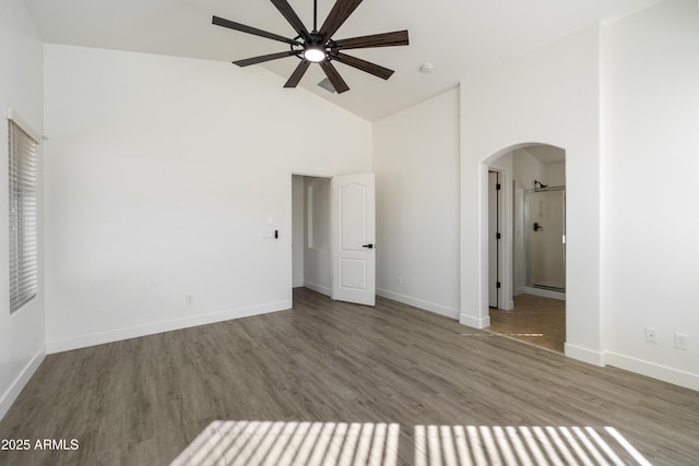 unfurnished bedroom with high vaulted ceiling and wood-type flooring