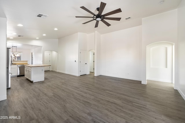 unfurnished living room featuring lofted ceiling, dark wood-type flooring, and ceiling fan