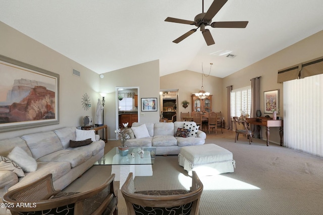 carpeted living room featuring vaulted ceiling and ceiling fan with notable chandelier