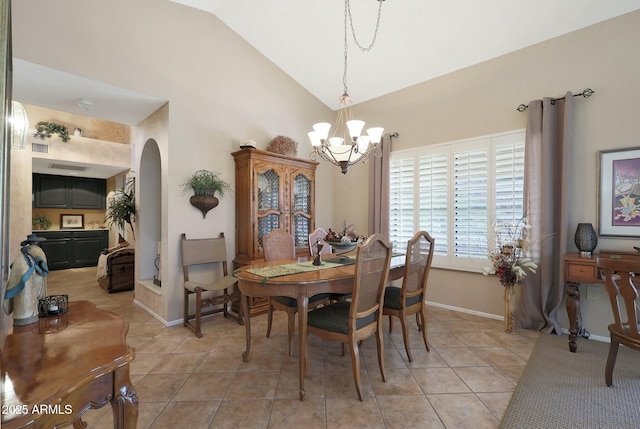 dining area with a chandelier, light tile patterned floors, and lofted ceiling