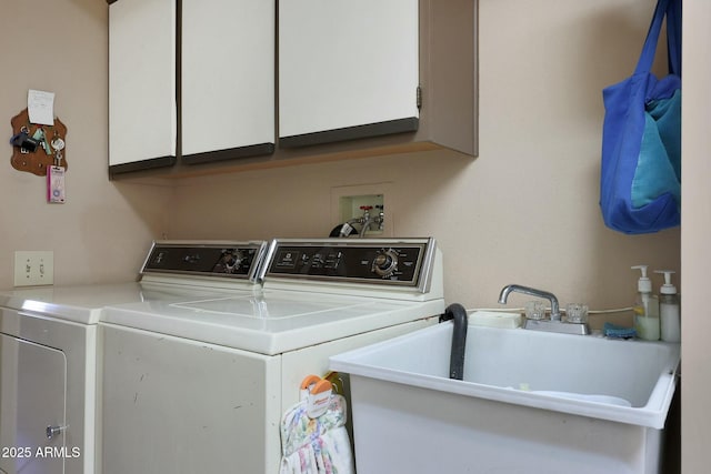 clothes washing area featuring sink, cabinets, and washer and dryer