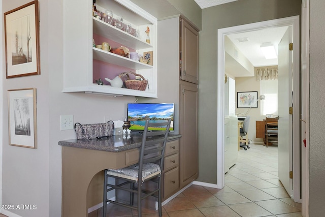 home office with light tile patterned flooring and built in desk