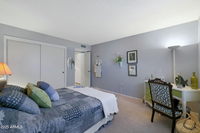 carpeted bedroom with a textured ceiling and a closet