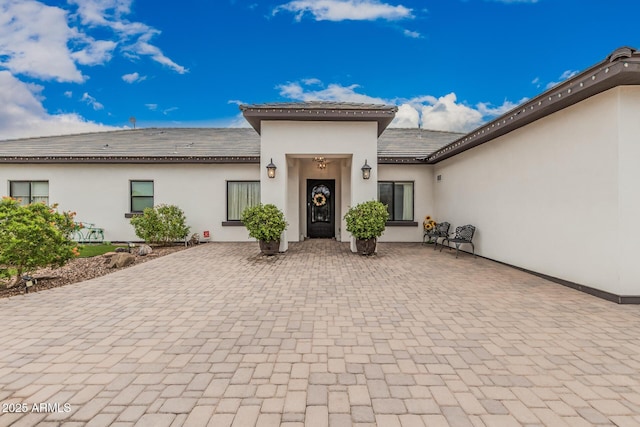 view of front of house featuring stucco siding and a tiled roof