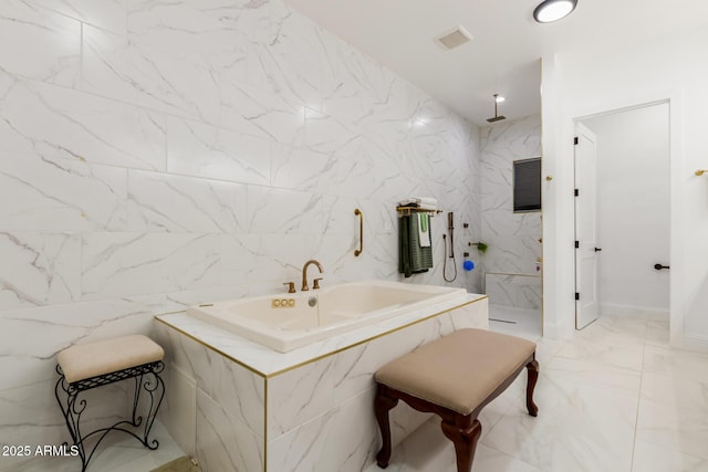 bathroom with a garden tub, marble finish floor, recessed lighting, a marble finish shower, and tile walls