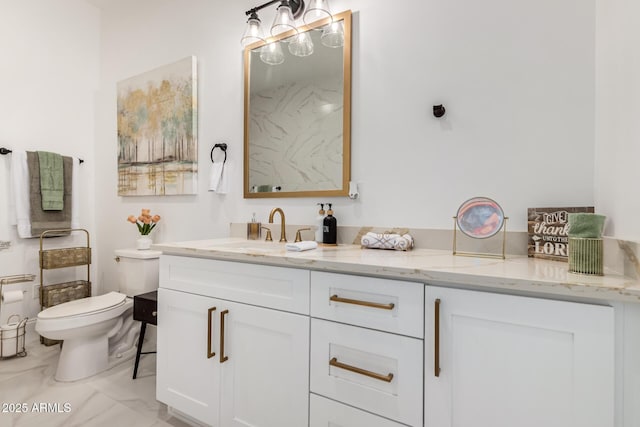 bathroom with marble finish floor, toilet, and vanity