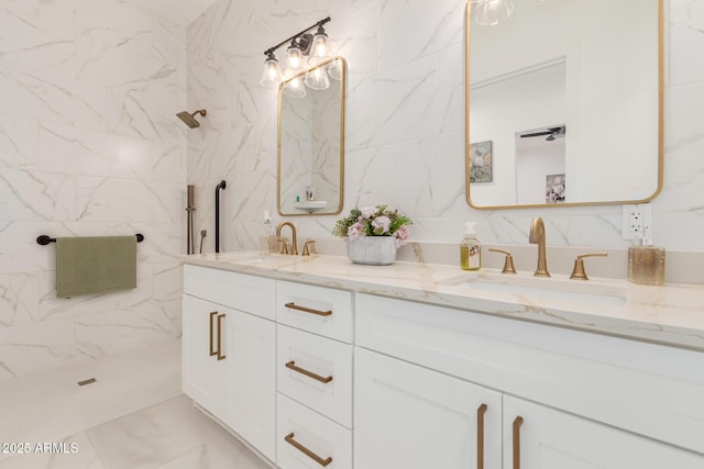 full bath with marble finish floor, tile walls, a shower, and a sink