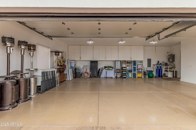 garage with electric panel and water heater